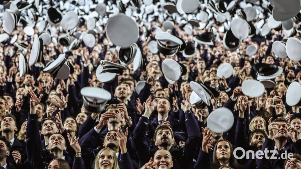Die Mützen fliegen hoch bei der Vereidigungsfeier der Polizeianwärter. Bild: Oliver Berg/dpa