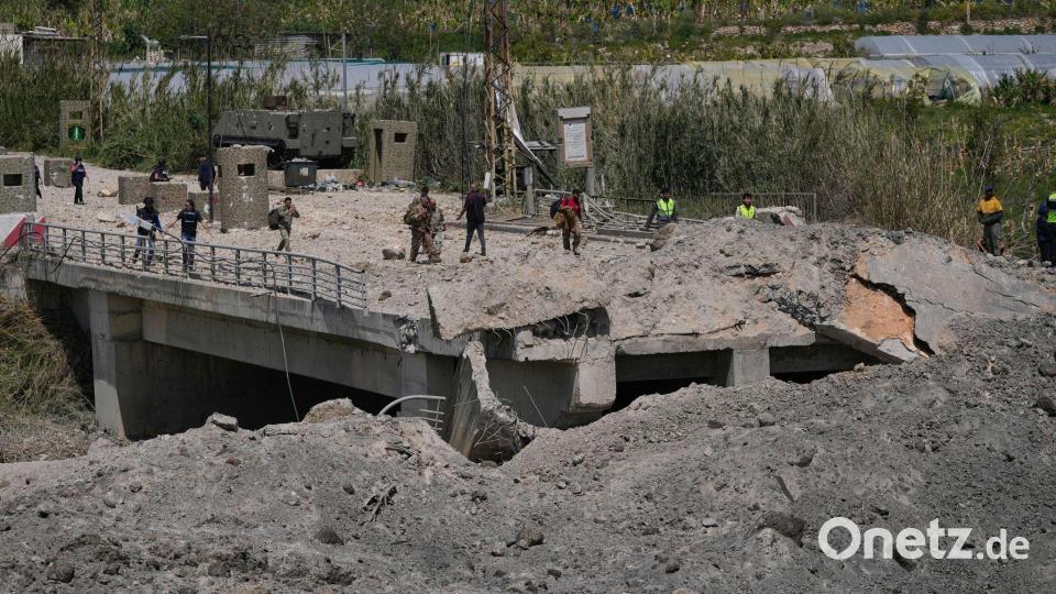 Soldaten und Zivilisten überqueren eine zerstörte Brücke, die bei einem israelischen Luftangriff nahe der Küstenstadt Tyrus im Libanon getroffen wurde. Bild: Mohammed Zaatari/AP/dpa