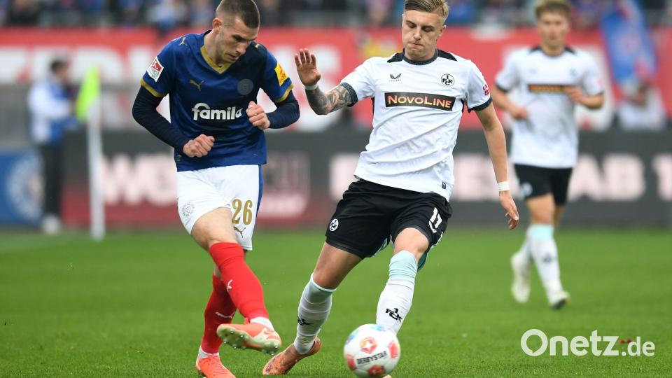 Kaiserslauterns Norman Bassette (r) stört den Kieler Torschützen David Zec. Bild: Daniel Bockwoldt/dpa