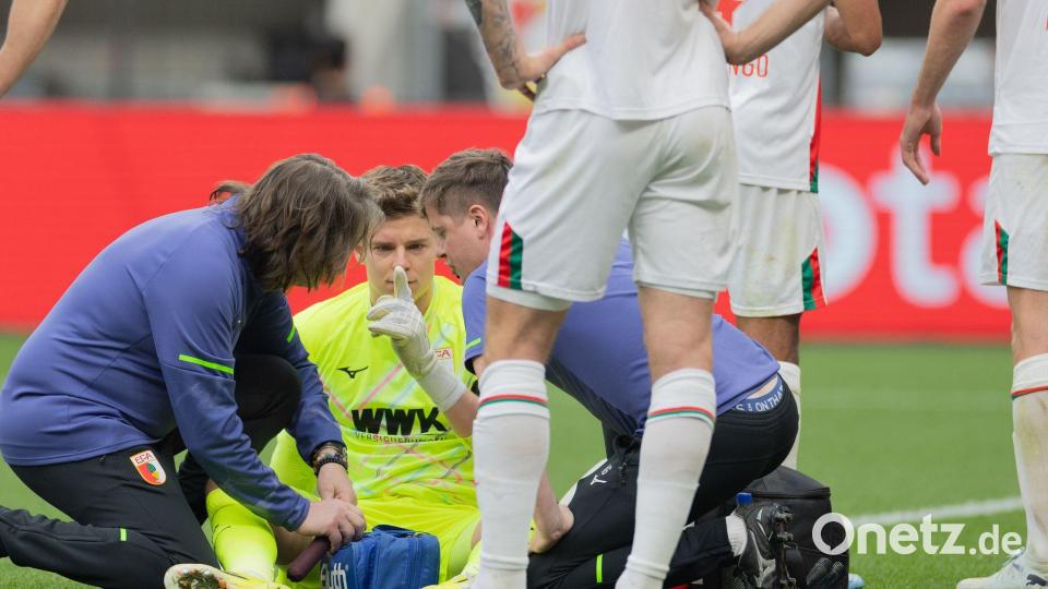 Auch eine kurze Behandlungspause nach einer Abwehr mit dem Kopf konnte Augsburgs Keeper Finn Dahmen nicht aus dem Rhythmus bringen. Bild: Rolf Vennenbernd/dpa