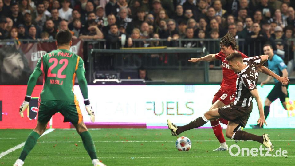 Die aus Sicht von Alexander Blessin strittige Szene vor dem Strafstoß: Kölns Jakub Kaminski (M,) und Karol Mets (FC St. Pauli) kämpfen um den Ball. Bild: Christian Charisius/dpa