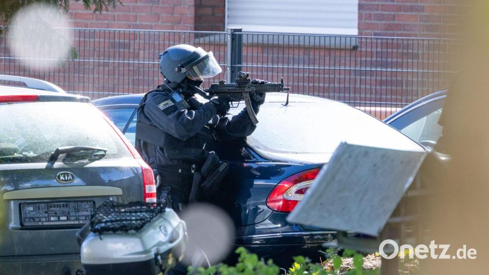 Ein Polizist hält in Moers eine Maschinenpistole im Anschlag. Zuvor war es zu einer Auseinandersetzung am Haus einer religiösen Gemeinde gekommen. Bild: Jan Ohmen/dpa