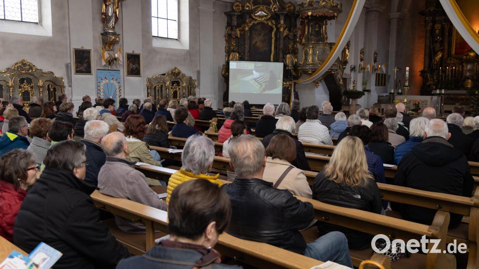Blick ins Publikum in der Stadtpfarrkirche Mariä Himmelfahrt in Erbendorf: Um dem Organisten folgen zu können, wurde an einem der Seitenaltäre eine große Leinwand aufgebaut, die das Spiel von der Empore per Video übertrug. Bild: Roland Wellenhoefer