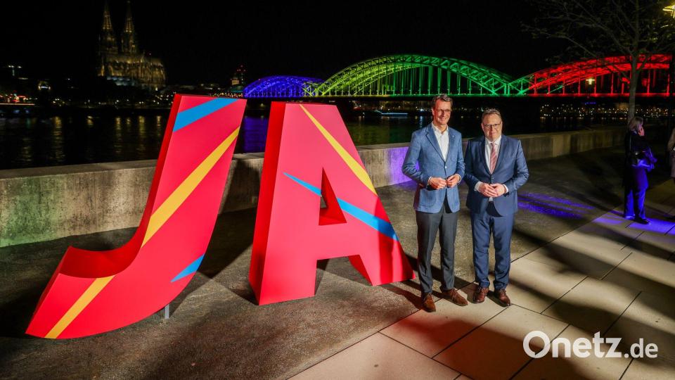 Ministerpräsident Hendrik Wüst (l) und Kölns Oberbürgermeister Torsten Burmester freuen sich über das Ja beim Olympia-Entscheid. Bild: Christoph Reichwein/dpa