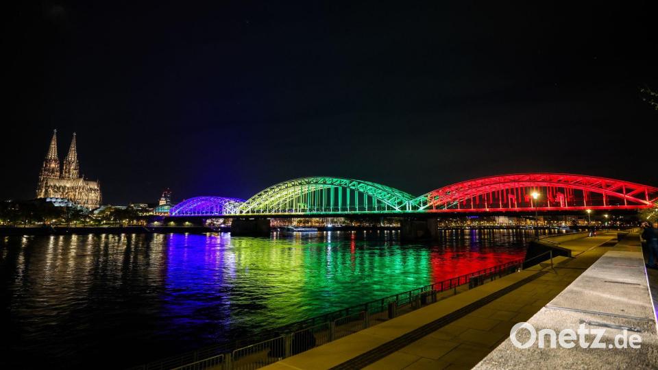 Die Hohenzollernbrücke leuchtet in den olympischen Farben. Bild: Christoph Reichwein/dpa