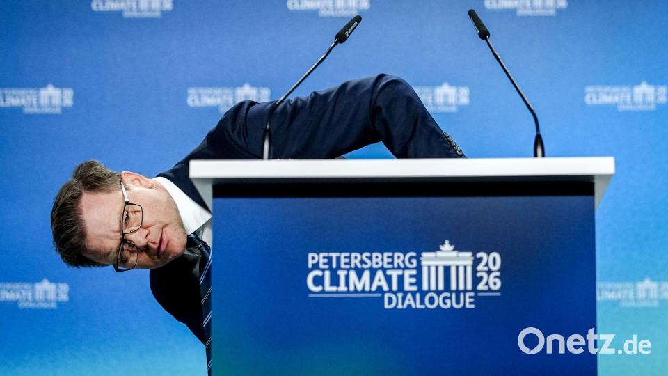 Umweltminister Carsten Schneider (SPD) beugt sich beim 17. Petersberger Klimadialog neben das Pult. Bild: Kay Nietfeld/dpa