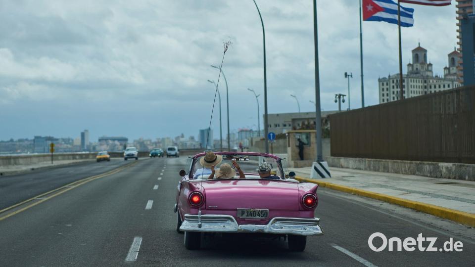 Ein US-Oldtimer transportiert Touristen an der US-Botschaft in Havanna vorbei. Bild: Ramon Espinosa/AP/dpa