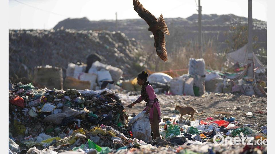Eine Frau sucht auf einer Mülldeponie im indischen Jammu nach etwas Verwertbarem. Bild: Channi Anand/AP/dpa