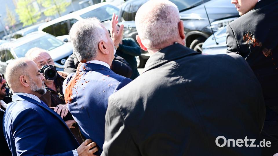 Reza Pahlavi, beschmiert mit roter Flüssigkeit. Bild: Sebastian Christoph Gollnow/dpa