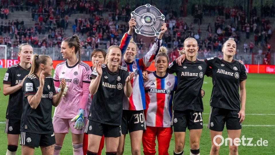 Bayern Münchens Spielerinnen jubeln nach dem Spiel gegen den 1. FC Union Berlin mit der Nachbildung einer Meisterschale über den Sieg. Bild: Soeren Stache/dpa