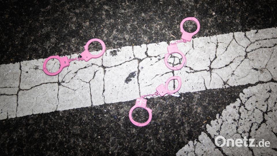 Rosa Handschellen liegen während einer Demonstration vor dem White House Correspondents' Dinner auf dem Boden in Washington. Bild: Allison Robbert/AP/dpa
