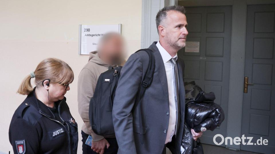 Der Zeuge (Mitte des Bildes) wird von seinem Anwalt (rechts im Bild) in den Gerichtssaal begleitet. Bild: Christian Charisius/dpa