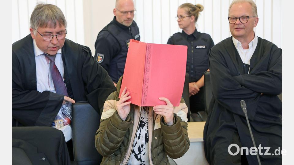 Die Angeklagte sitzt mit Aktendeckel vor dem Gesicht zwischen ihren Verteidigern Andreas Ohm (l-r) und Thomas Löcker. Bild: Bernd Wüstneck/dpa
