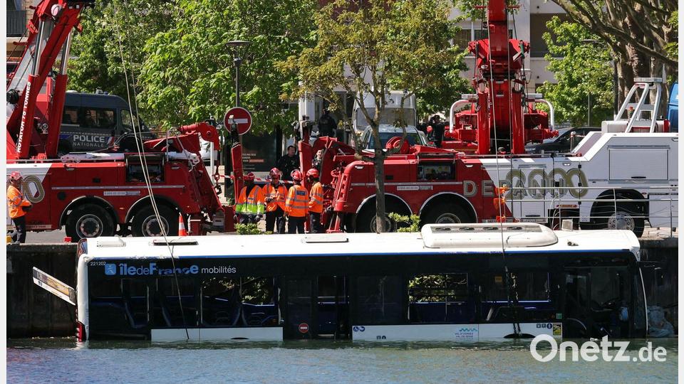 Der Linienbus wird von Kränen aus dem Fluss geborgen. Bild: Thomas Samson/AFP/dpa