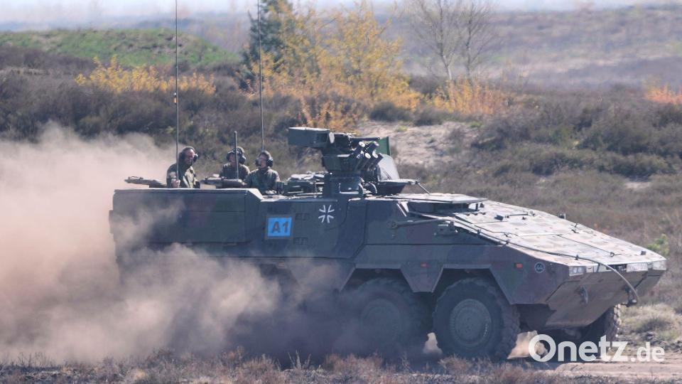 Im Boxer geht es für Merz durch die staubige Heide. Bild: Markus Schreiber/AP POOL/dpa