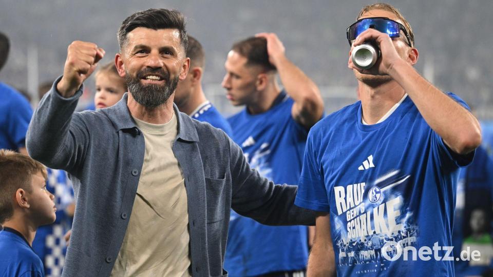Der Trainer, die Spieler und ein Bier - die Party begann schon auf dem Rasen. Bild: Bernd Thissen/dpa