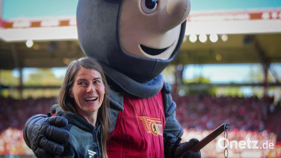 Union-Trainerin Marie-Louise Eta wird von Club-Maskottchen Ritter Keule umarmt. Bild: Soeren Stache/dpa