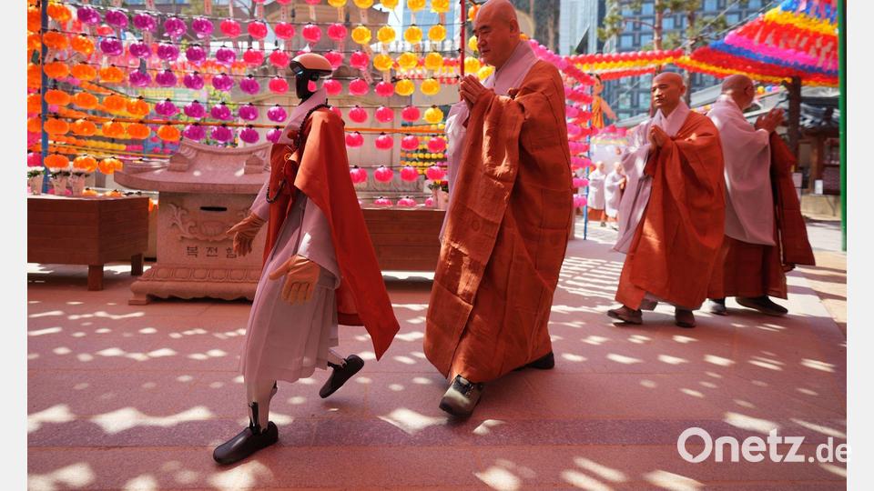 Ein Roboter und buddhistische Mönche umrunden zusammen eine Pagode während einer Zeremonie vor dem Geburtstag Buddhas im koreanischen Seoul. Bild: Lee Jin-man/AP/dpa