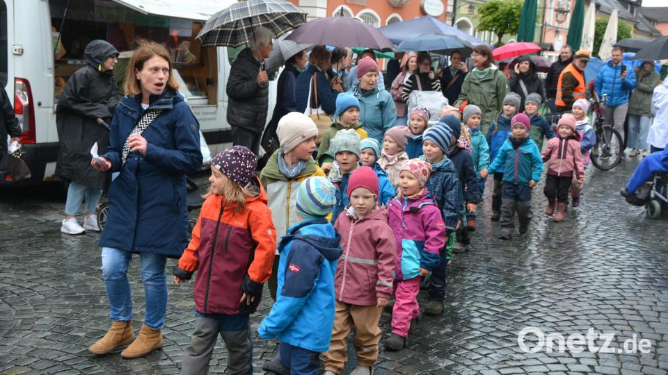 Einzug der 21 Kinder des Kemnather Waldkindergartens, die dann später rund um den Maibaum ihre Lieder und Tänze aufführten. Die Kinder jedenfalls hatten keine Angst vor dem Regen. Bild: jr