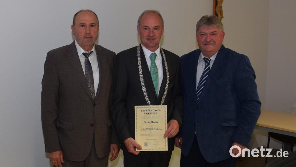 Bürgermeister Georg Bocka mit der Bestellungsurkunde zum Standesbeamten. Zweiter Bürgermeister Roman Bauer (links) und Dritter Bürgermeister Hans-Peter Reil gratulieren. Bild: Tanja Pflaum