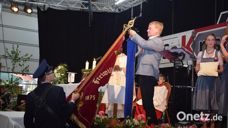 Schirmherr Markus Schiesl befestigte das Erinnerungsband an der restaurierten Fahne. Bild: bnr