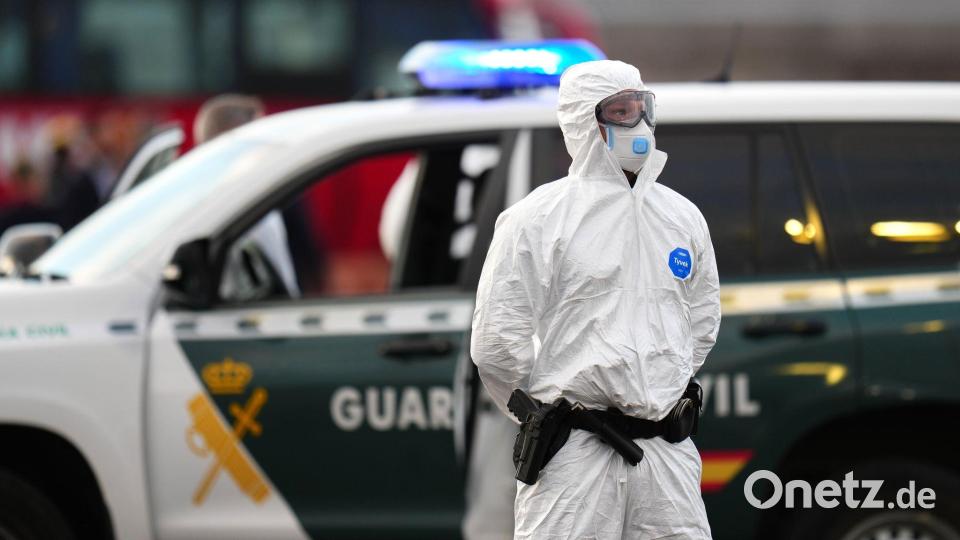 Die Sicherheitsvorkehrungen sind hoch: Ein Mitglied der Guardia Civil, das einen weißen Schutzanzug und Maske trägt, steht auf dem Hafengelände. Bild: AP/dpa