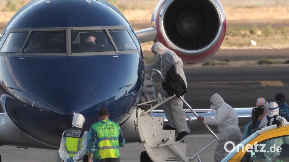 Die Passagiere betraten in Schutzkleidung das Flugzeug. Bild: Arturo Rodriguez/AP/dpa