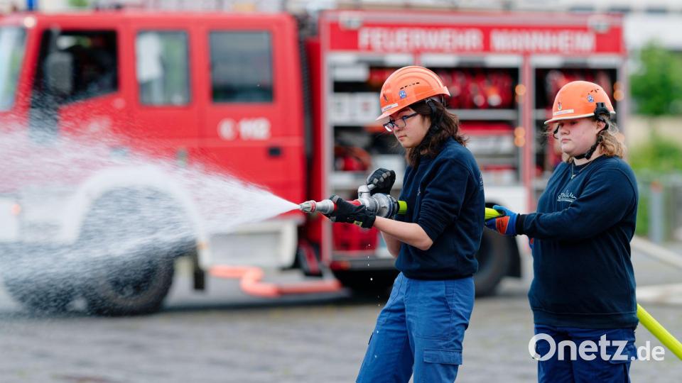 Ilias (links) und Annabella, Mitglieder der Jugendfeuerwehr in Mannheim, halten bei einer Übung einen Feuerwehrschlauch in den Händen. Bild: Uwe Anspach/dpa