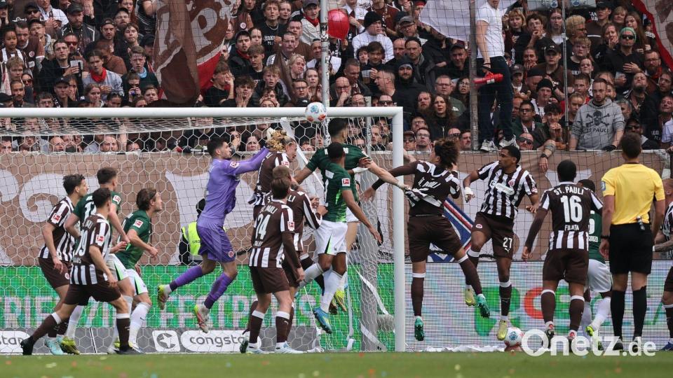 Wolfsburgs Konstantinos Koulierakis (M) traf im Abstiegsgipfel beim FC St. Pauli zum 1:0. Bild: Christian Charisius/dpa