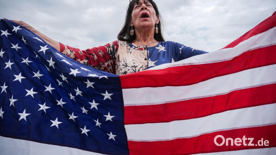 Viele Teilnehmer haben US-Flaggen bei sich. Bild: Julia Demaree Nikhinson/AP/dpa
