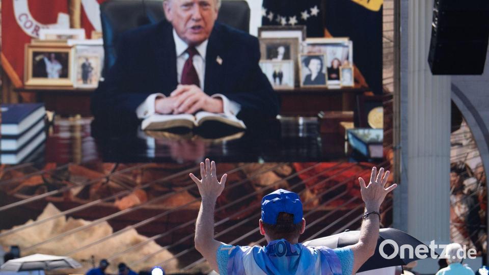 Eine Person betet, während eine aufgezeichnete Videobotschaft von US-Präsident Donald Trump abgespielt wird. Bild: Julia Demaree Nikhinson/AP/dpa