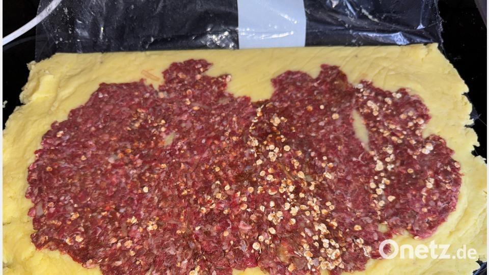 Den Kloßteig auf einer Frischhaltefolie ausrollen und das Hackfleisch darauf verteilen. Bild: Ilse Hauer