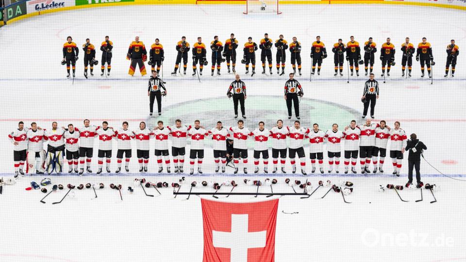 Die Schweizer (unten) und das deutsche Team steht auf dem Eis. Bild: Claudio Thoma/KEYSTONE/dpa