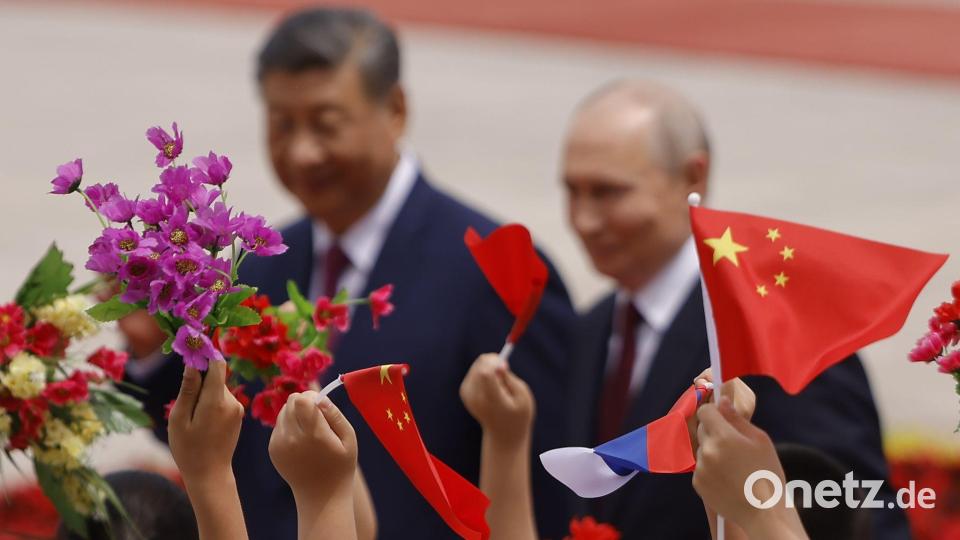 Mit Blumen und Fähnchen empfingen chinesische Kinder den Gast aus Moskau. Bild: Maxim Shemetov/Pool Reuters/AP/dpa