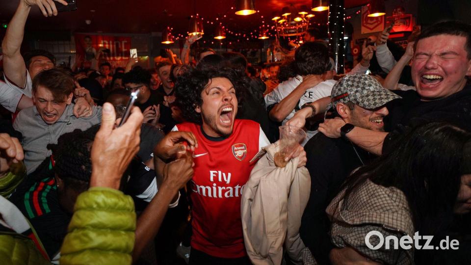 Arsenal-Anhänger feiern in einem Pub in der Nähe des Arsenal-Stadions, nachdem die Fußballmannschaft des FC Arsenal den Titel in der Premier League gewonnen hat. Bild: Alberto Pezzali/AP/dpa