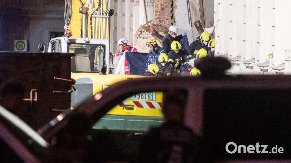 Einsatzkräfte der Feuerwehr tragen hinter Sichtschutz eine Leiche aus dem Trümmerfeld eines eingestürzten Hauses in Görlitz. Bild: Paul Glaser/dpa