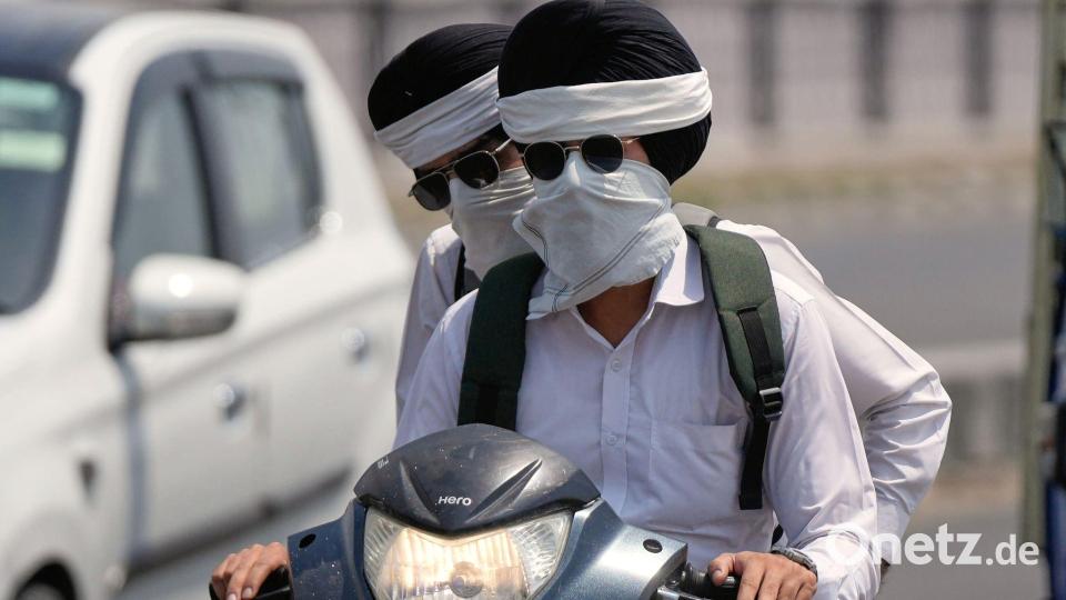 Hitze in Indien: Pendler schützen sich in Jammu vor der Sonne. Bild: Channi Anand/AP/dpa