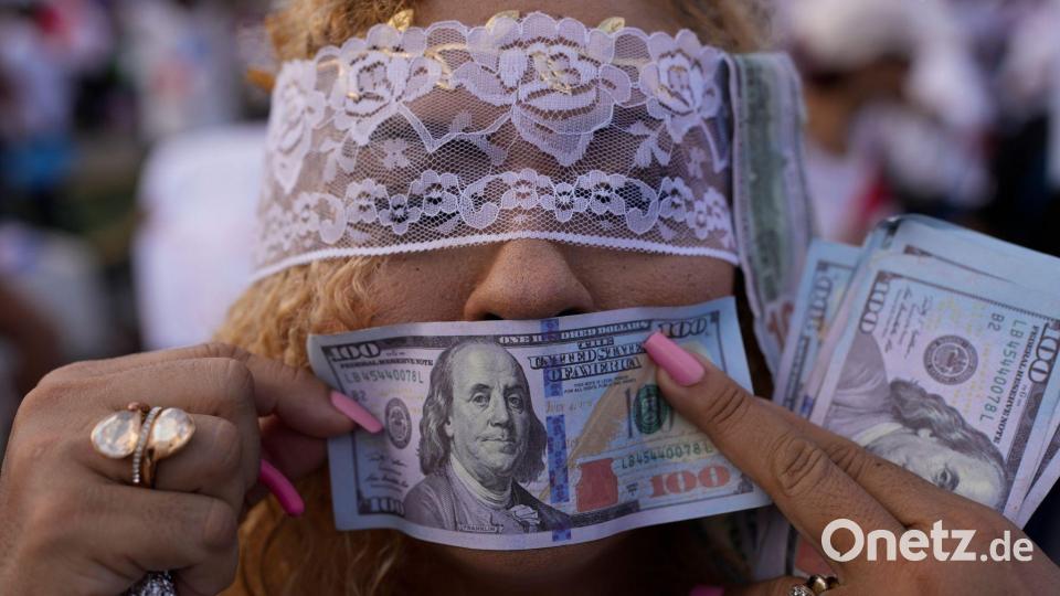 Eine Demonstrantin hält während einer Demonstration in Panama-Stadt gegen die Politik von Panamas Präsident Mulino eine falsche US-Banknote vor ihren Mund. Bild: Matias Delacroix/AP/dpa