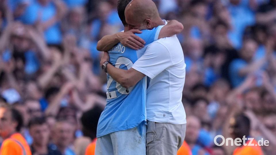 Manchester Citys Trainer Pep Guardiola (r) umarmt Bernardo Silva. Für beide war es das letzte City-Spiel. Bild: Alastair Grant/AP/dpa