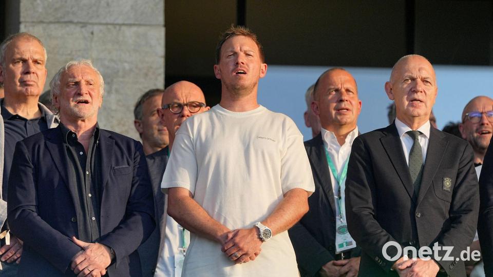 Julian Nagelsmann (m.) steht zwischen DFB-Sportdirektor Rudi Völler (l.) und Verbandschef Bernd Neuendorf (r.) auf der Tribüne des Berliner Olympiastadions. Bild: Michael Kappeler/dpa
