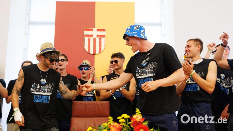 Besondere Ehre: Die Spieler tragen sich ins Goldene Buch ein. Bild: Friso Gentsch/dpa