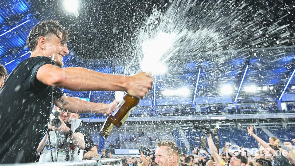 Arena. Spieler von SC Paderborn 07 spritzt mit einer Sektflasche im Stadion. Bild: Swen Pförtner/dpa