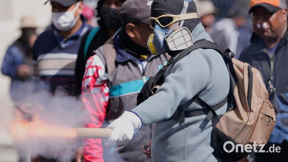 Ein Demonstrant wirft einen Feuerwerkskörper auf die Polizei. Bild: Juan Karita/AP/dpa