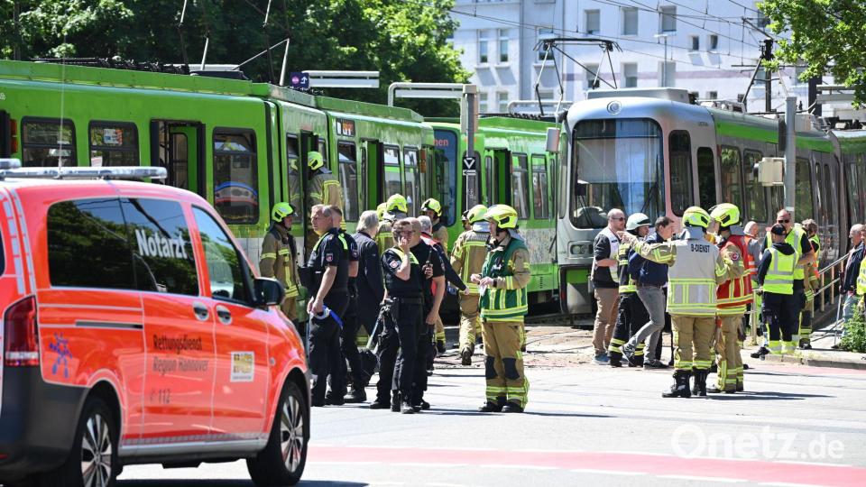 Einsatzkräfte von Polizei und Feuerwehr stehen nach einem Unfall neben zwei Stadtbahnen. Bild: Julian Stratenschulte/dpa