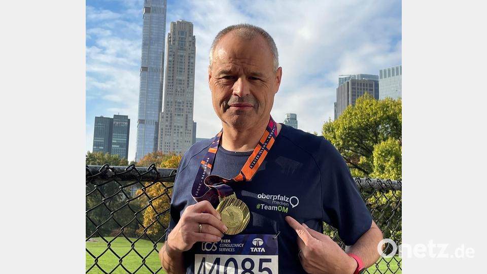 Vom Nofi-Lauf zum NEW-York-Marathon: Stefan Zaruba, im Oberpfalz-Medien-Shirt, glücklich und mit Medaille im Central Park. Im Hintergrund ist der südliche Teil Manhattans zu sehen. Bild: privat