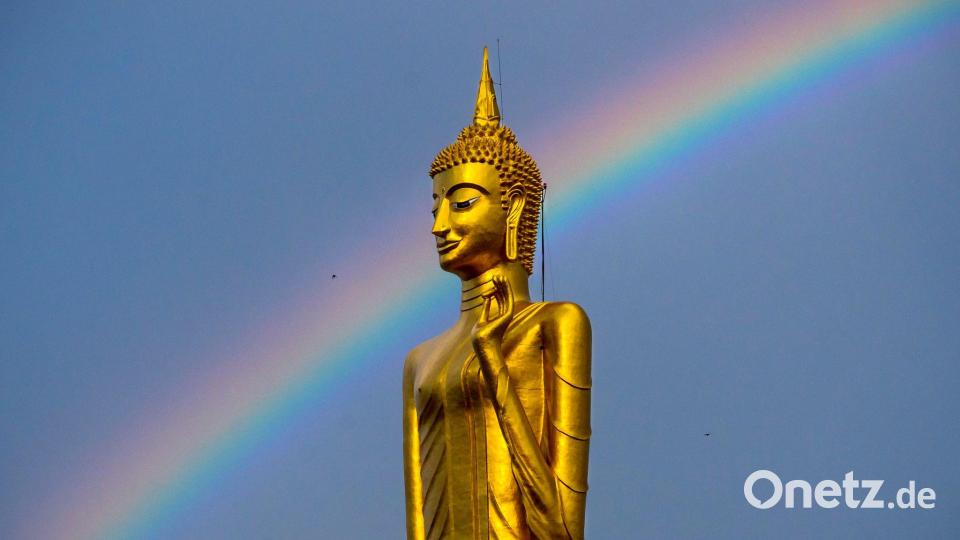 Ein Regenbogen ist hinter der stehenden Buddha-Statue Luang Pho Yai des Wat Buraphaphiram in Roi Et, Thailand, zu sehen. Bild: Adryel Talamantes/ZUMA Press Wire/dpa