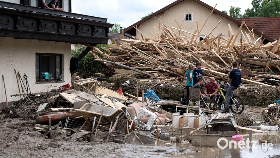 Nach der Flut im Juni 2016 sitzen Anwohner in der Innenstadt von Simbach am Inn zwischen Schlamm und Unrat auf der Straße. (Archivbild) Bild: Sven Hoppe/dpa