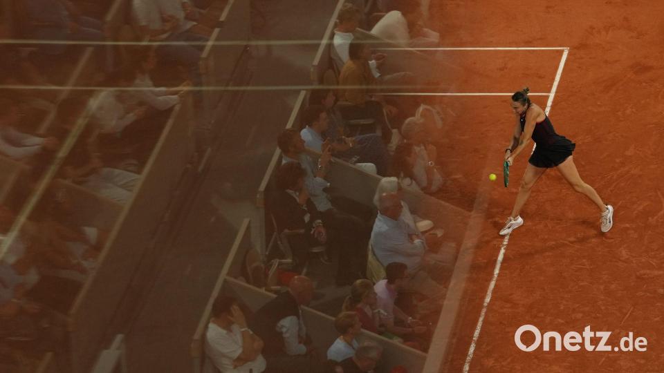 Die Fans spiegeln sich in einer Glaswand bei den French Open, während Aryna Sabalenka eine Rückhand gegen Naomi Osaka spielt. Bild: Aurelien Morissard/AP/dpa