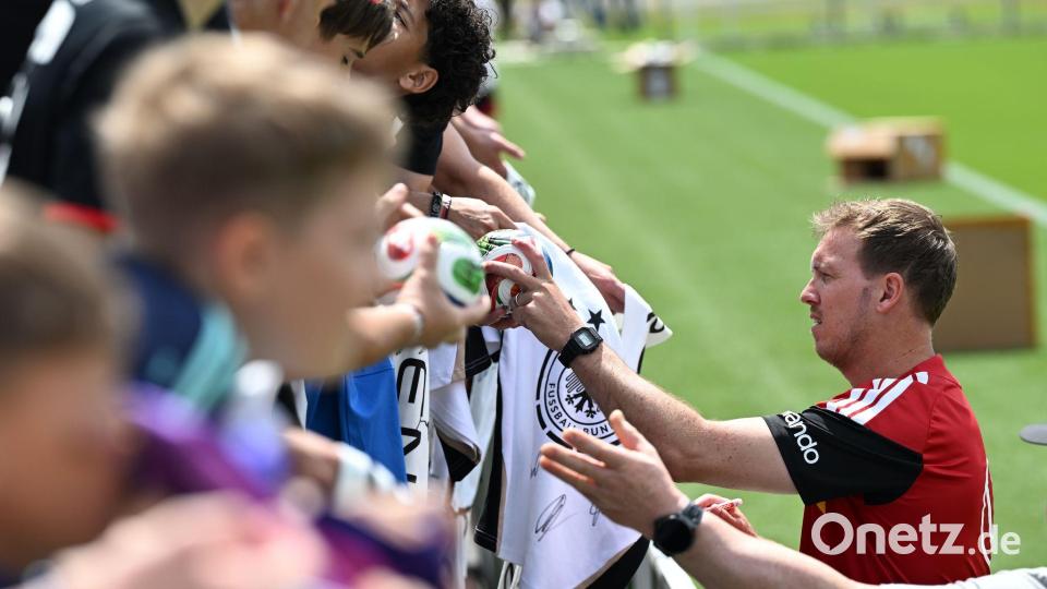 Julian Nagelsmann schreibt Autogramme für Fans der Nationalmannschaft (Archivbild). Bild: Federico Gambarini/dpa