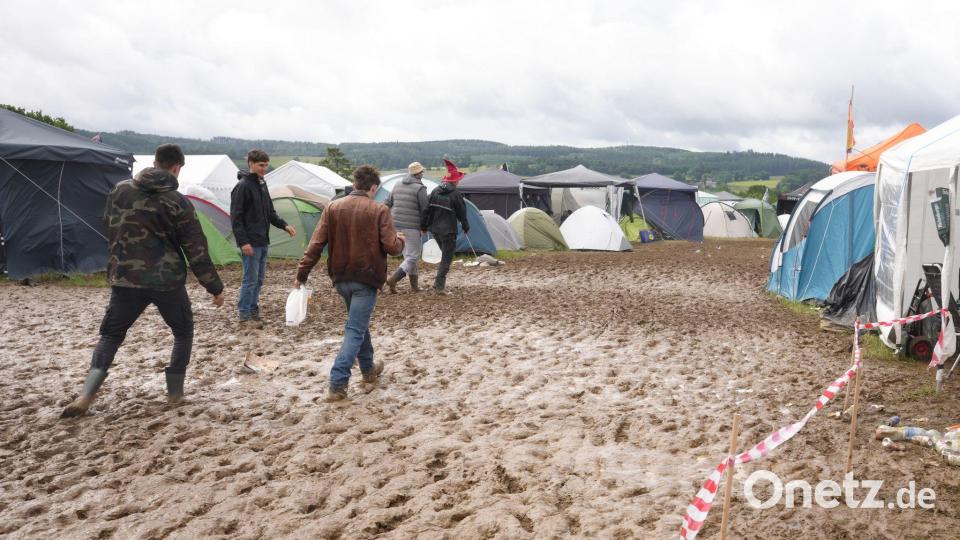Rock am Ring: Camper waten nach Regen durch den Schlamm Bild: Thomas Frey/dpa